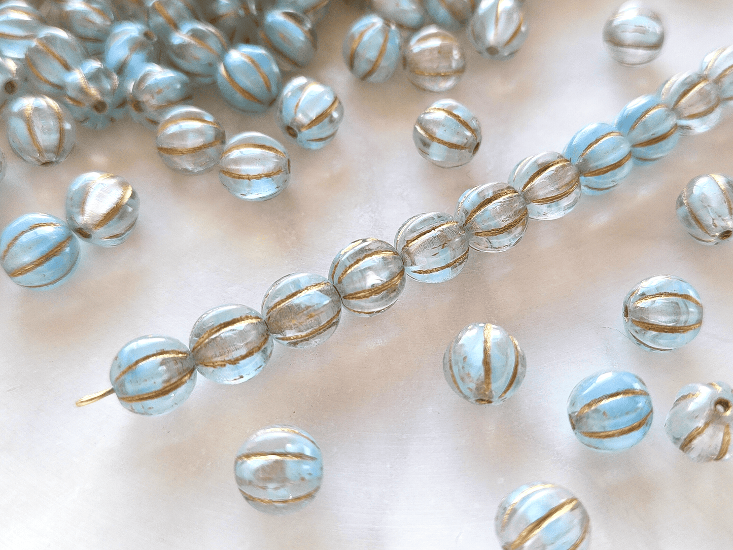Melon beads 8mm - colorless, light blue & gold