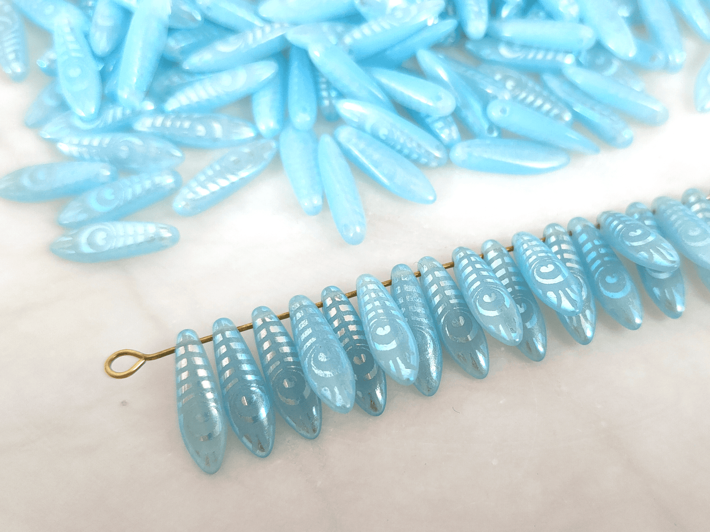 Dagger beads 5x16mm - light blue & iris feather motif