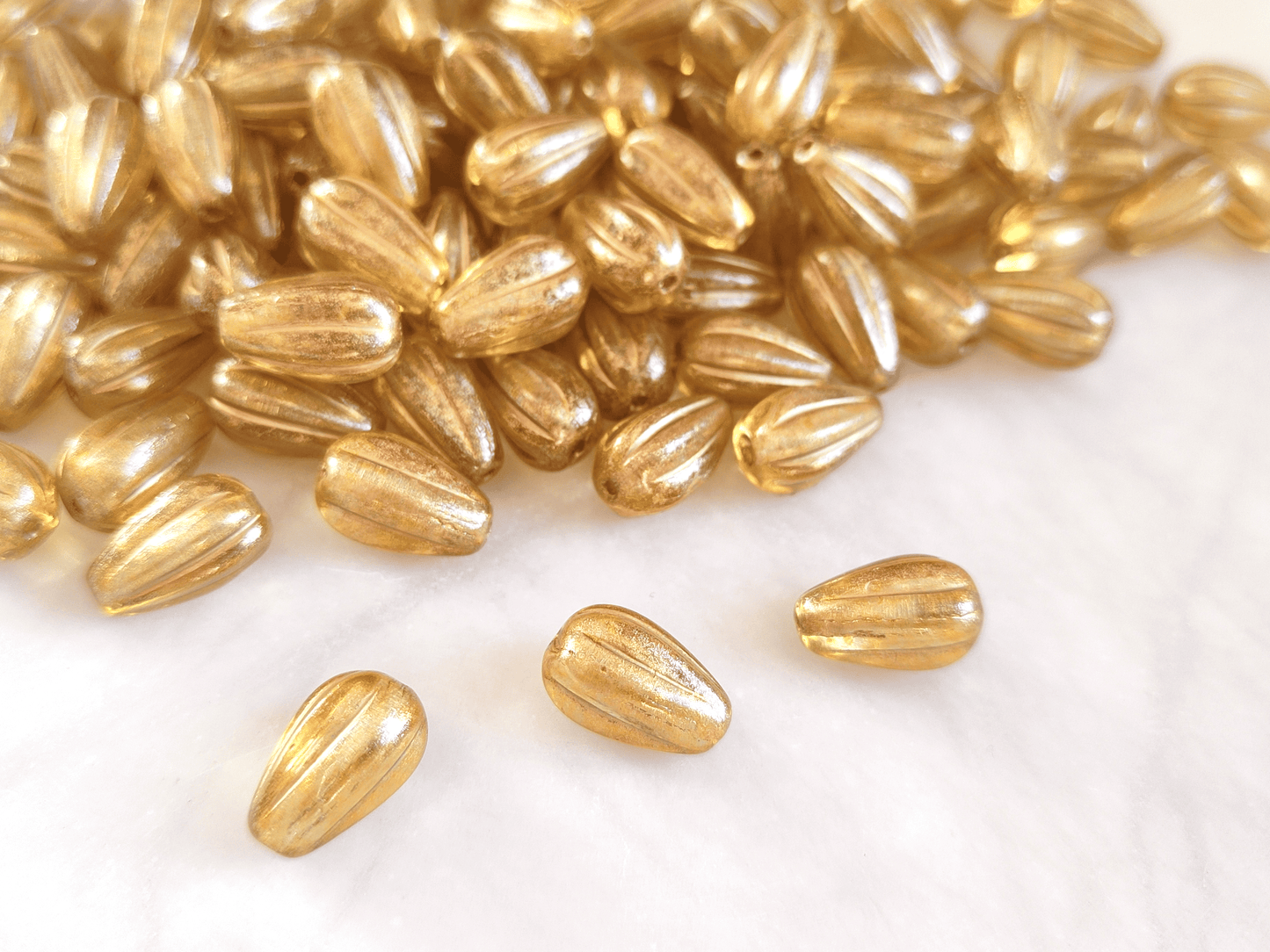 Melon drop beads 13x8mm - colorless & gold shimmer